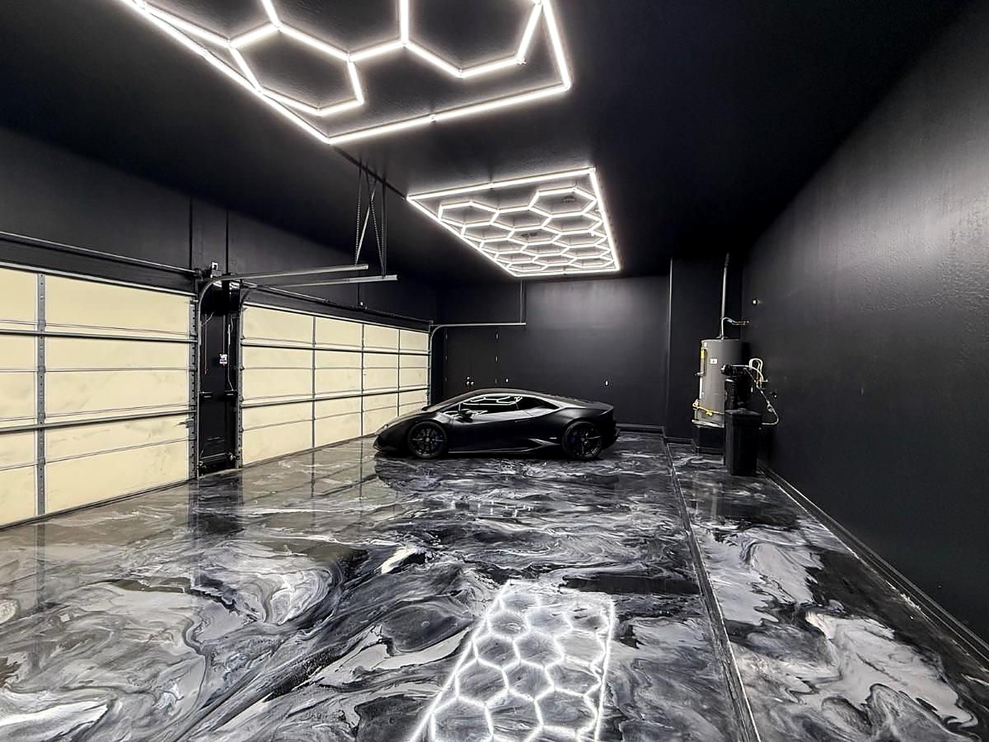 Black metallic epoxy garage floor with hex lighting and luxury car in Hurricane Utah